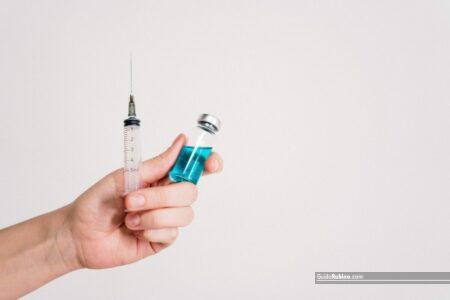 Person Holding Syringe and Vaccine Bottle